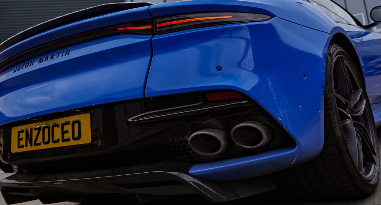 Rear three-quarter view of the Aston Martin DBS Superleggera showing quad exhaust pipes and carbon diffuser